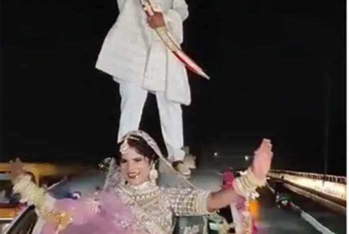 सोशल-मीडिया-पर-वायरल-होने-के-चक्कर-में-एक-दूल्हा-दुल्हन-ने-ट्रैफिक-नियमों-की-धज्जियां-उड़ाईं,-कार-पर-दुल्हे-का-स्टंट